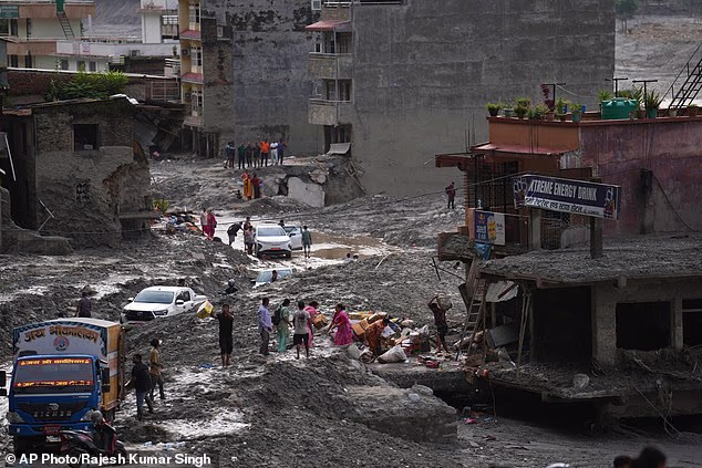People salvage their belongings from a building damaged by flash flooding in Nuwakot district of Nepal, Tuesday, September 1, 2026