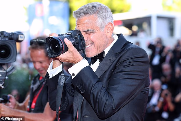 George Clooney was honoured with the prestigious Golden Lion award as the Venice Film Festival opened last night but he swapped his award for a film camera, borrowing a photographer's lens to take his own pictures instead