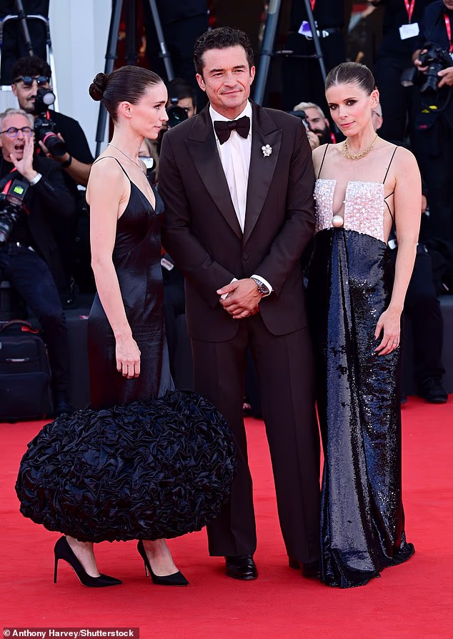 Sisters Rooney and Kate Mara pose with onscreen lover Orlando Bloom at the Bucking Fastard premiere in Venice as they play identical twins who spoke in unison and loved the same man