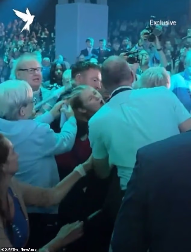 Video footage showed audience members pulling the hair and grabbing the head of a heckler, who was one of a number of protesters who tried to interrupt Nigel Farage's keynote address