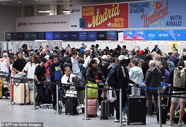 Passengers stand with their luggage as they queue to check-in at London Gatwick yesterday