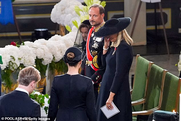 Norway's new Queen Mette-Marit wiping away her tears as the late Norwegian monarch was laid to rest