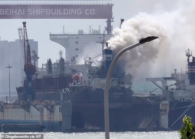 Smoke billows out from a cargo ship that caught fire while docked at a port in the city Qingdao in eastern China's Shandong province