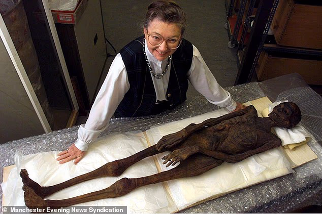 Dr Rosalie David, keeper of etymology at Manchester Museum, pictured with the mummified remains of Asru