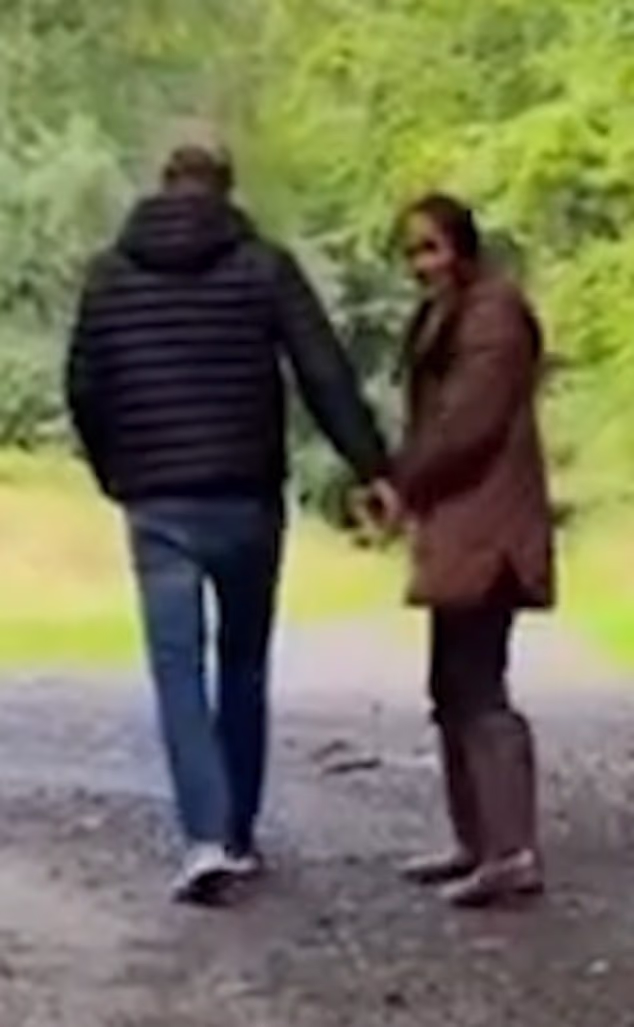 Meghan and Harry are shown walking in wellingtons through the woods, with Meghan beckoning to the camera, thought to be held by one of the children, and saying 'Come on, you!'