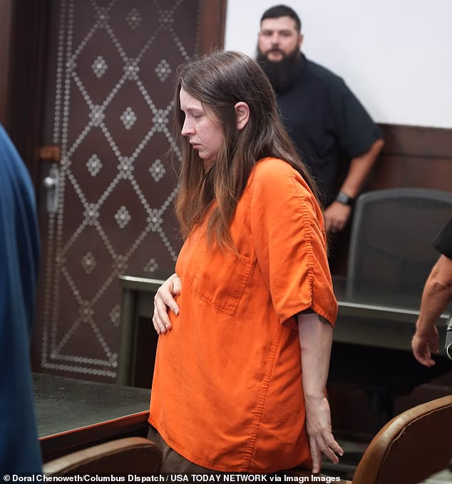 Clad in baggy orange prison garb, Elizabeth Siders, 34, seemed to shield her stomach as she entered the court led by her attorney Tommy Stolley, and flanked by sheriff¿s officers