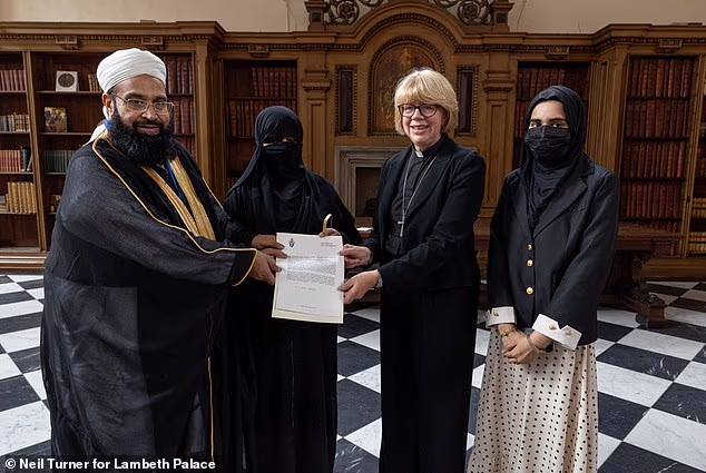 Pakistani cleric Hafiz Tahir Ashrafi poses with his wife beside Mullally, who looks faintly uncomfortable, and another unidentified woman in the 13th century banqueting hall