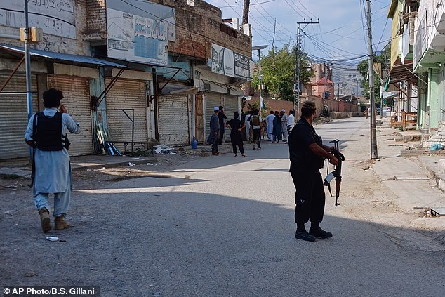 Police officers secure a road leading to the site of a powerful bomb at a mosque in Kohat