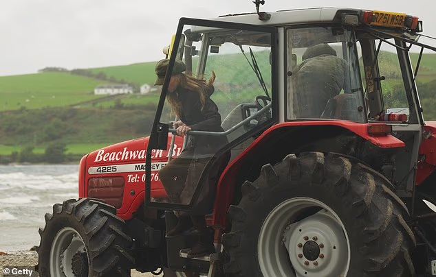Kate can be seen emerging from the cab of a tractor, with Prince William behind the wheel, as the couple joined local residents on the Isle of Bute on a beach litter pick