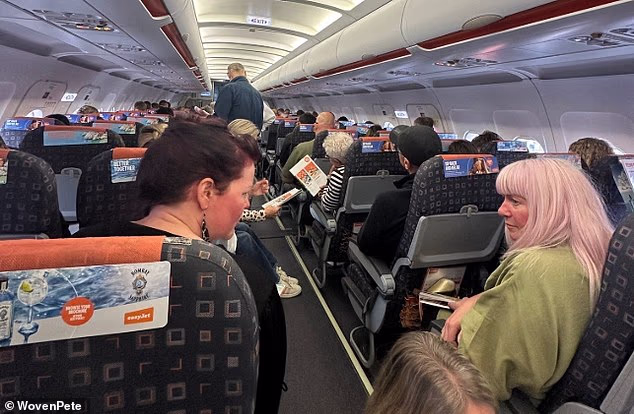Passengers wait to take off on an easyJet flight this morning as services are delayed again