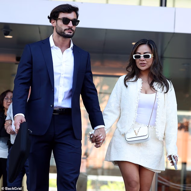 Iris Au holds the hand of her boyfriend, Love Island winner Davide Sanclimenti, as they leave Los Angeles Federal Courthouse on Monday after she was given an 18-month prison sentence