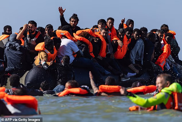 Migrants try to board a smuggler's boat off the beach of Equihen-Plage, northern France, on Wednesday