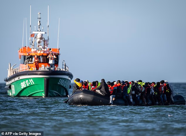 Channel migrants aboard a mega-dinghy arrived in Dover earlier this week after an unprecedented 38-hour voyage to the UK (Pictured: Personnel aboard a French sea rescue service SNSM boat watch as migrants aboard a smugglers' boat)