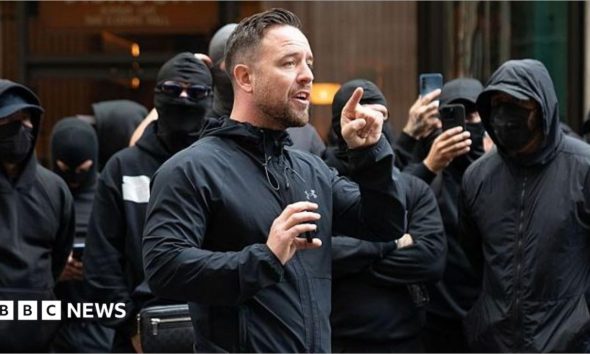 Danny Tommo, (Daniel Thomas) addresses the group of men outside the Daily Mail Offices at Associated Newspapers on September 9, 2026 in London, England. Leader of the self styled "Patriot Platform" Danny Tommo, (Daniel Thomas) led a group of men in balaclavas to the Daily Mail offices in South Kensington to peacefully protest against the paper's reporting of his Mother's details.