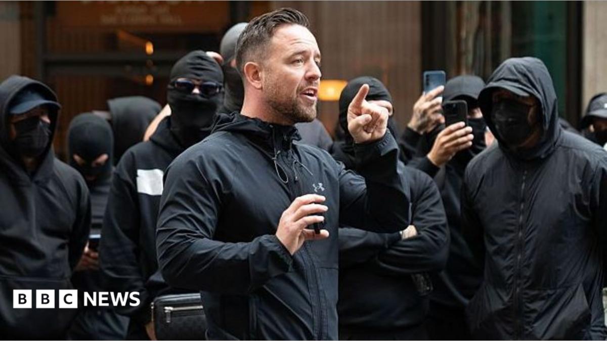 Danny Tommo, (Daniel Thomas) addresses the group of men outside the Daily Mail Offices at Associated Newspapers on September 9, 2026 in London, England. Leader of the self styled "Patriot Platform" Danny Tommo, (Daniel Thomas) led a group of men in balaclavas to the Daily Mail offices in South Kensington to peacefully protest against the paper's reporting of his Mother's details.