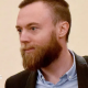 Jack Shepherd in court. He wears a shirt and jacket and has a beard