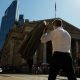 A commuter carries his jacket on a sunny day in the City of London