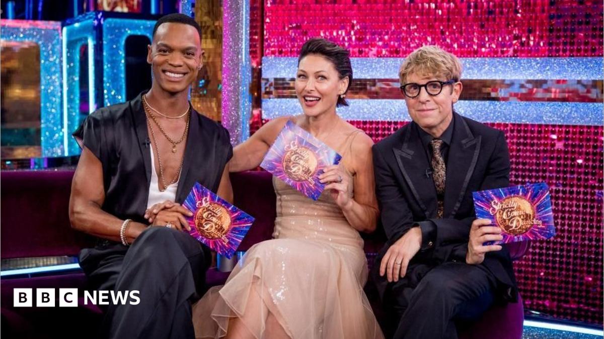 Left to right: Johannes Radebe, Emma Willis and Josh Widdicombe sit in a line on a sofa.