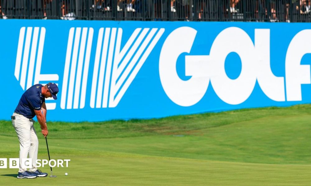 Golfer Bryson DeChambeau putts in front of a big blue and white LIV Golf sign