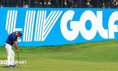 Golfer Bryson DeChambeau putts in front of a big blue and white LIV Golf sign