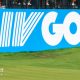 Golfer Bryson DeChambeau putts in front of a big blue and white LIV Golf sign