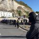 A row of masked men block a road at the entrance to the Port of Dover.