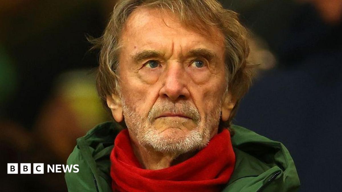 Sir Jim Ratcliffe in a green coat and red scarf