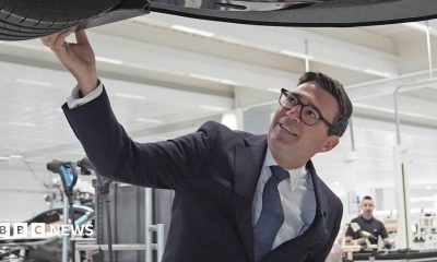 Prime Minister Andy Burnham looks at a car on the production line during a visit