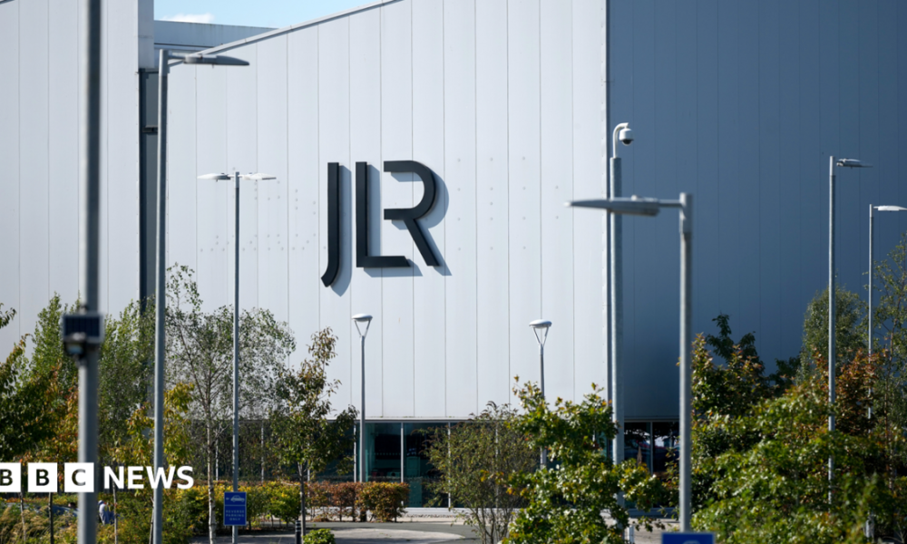 A large white building with the letters JLR in black writing on the side