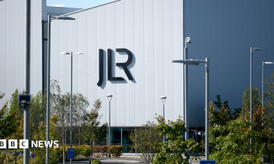 A large white building with the letters JLR in black writing on the side