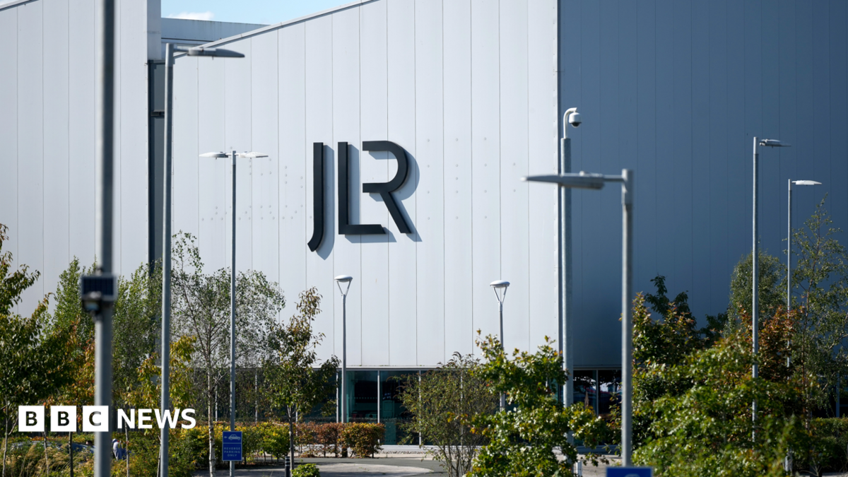 A large white building with the letters JLR in black writing on the side