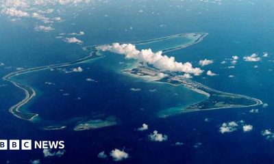 A bird's eye view of the Chagos Islands – officially known as the British Indian Ocean Territory – in the Indian Ocean, with white clouds in the sky.