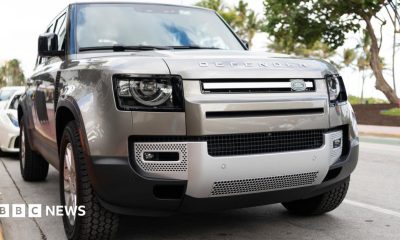 A silver Land Rover Defender parked on a road