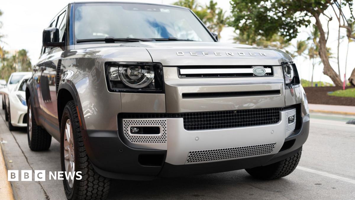 A silver Land Rover Defender parked on a road