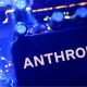 A smartphone display showing the Anthropic logo in black letters on an all-white background, laid on a laptop keyboard lit in pink and purple
