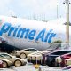 A parking lot filled with Tesla Cybercabs is seen in the foreground as the nose of a Prime Air cargo plane rests on the ground after the aircraft overran the runway and struck cars the previous day at Miami International Airport in Miami, Florida, on September 7, 2026.