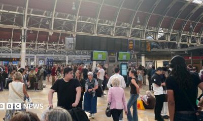 Crowds fill the concourse of London Paddington station with the departure boards blank showing no services.