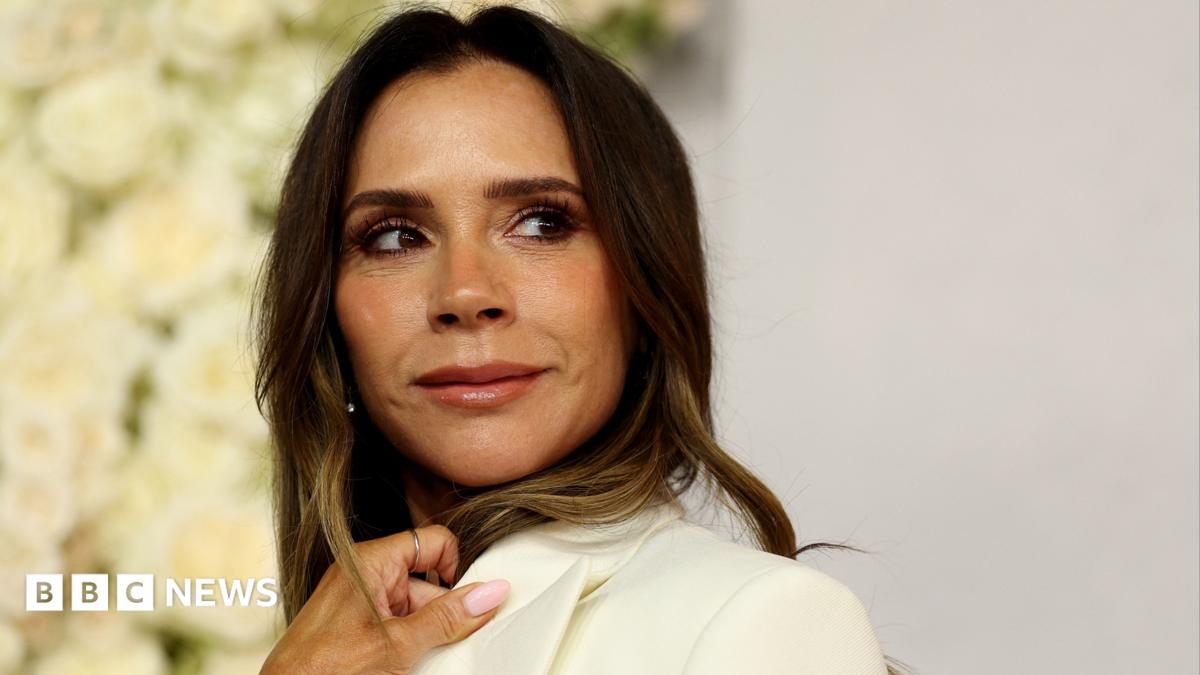 A woman with long brown hair looks at someone off-camera