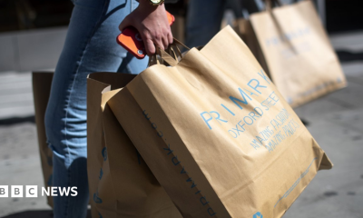 Woman carries Primark paper bags