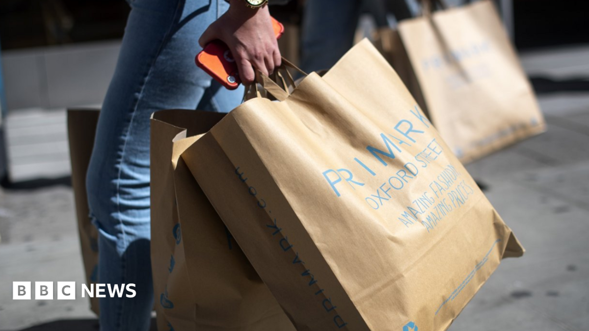 Woman carries Primark paper bags
