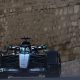 Mercedes' George Russell crests a hill during Azerbaijan Grand Prix second practice. In the background can be seen the walls of a castle and a cycling road sign