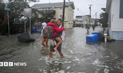 People walk in flooded streets in Surf City, New Jersey, on 26 September 2026