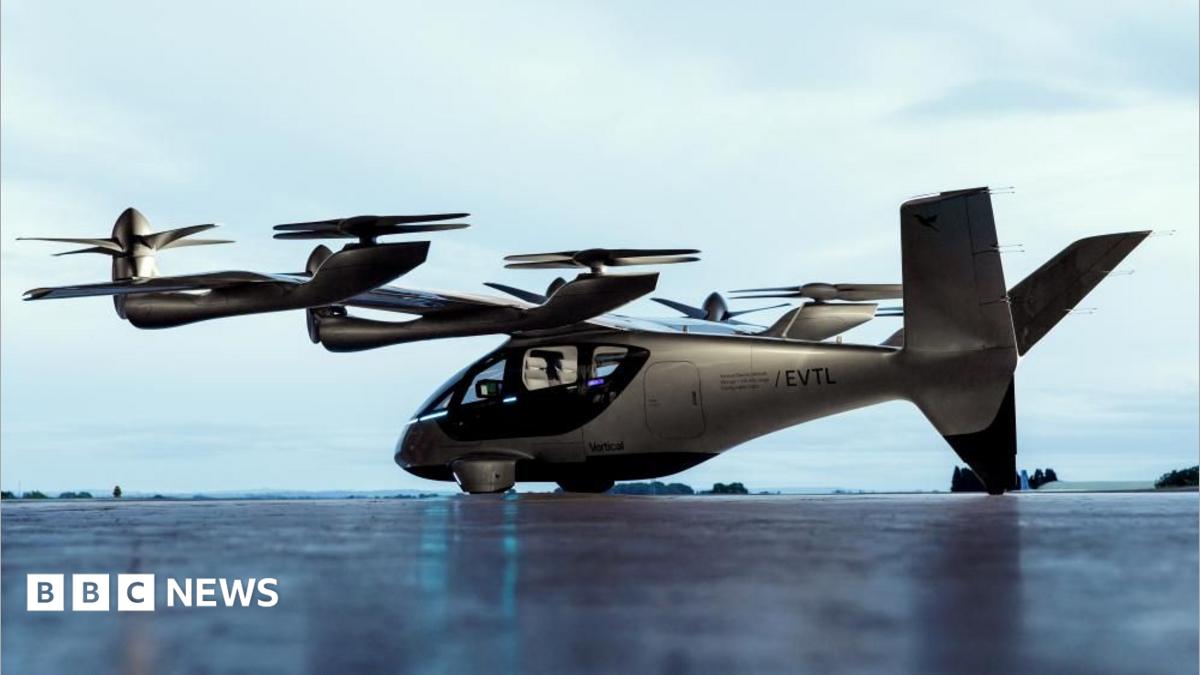 A Valo aircraft on the ground. It is silver and it has large propellers on each of its wings.
