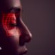Facial Recognition Technology Concept As Woman Has Red Grid Projected Onto Eye In Studio