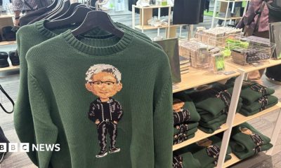 Green Nvidia jumpers with an image of the company's boss Jensen Huang on the front, hanging up on a store