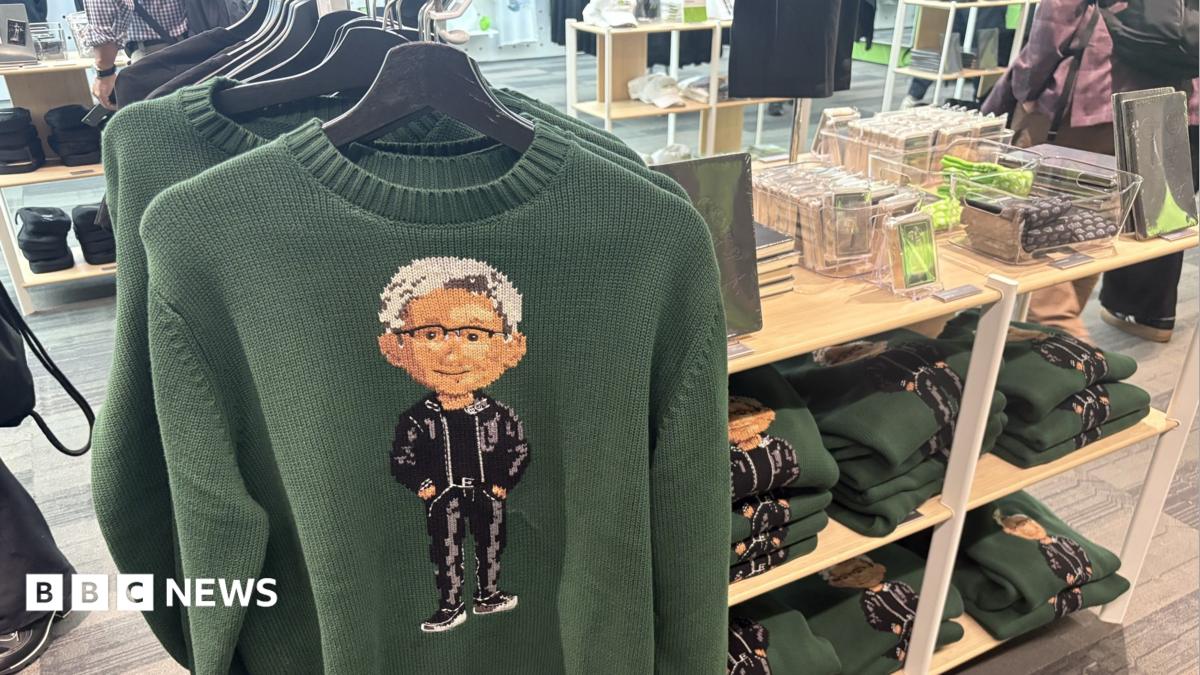 Green Nvidia jumpers with an image of the company's boss Jensen Huang on the front, hanging up on a store