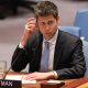 Sam Altman of OpenAI sitting before the US Security Council wearing a suit and tie while listening to a translation of comments.