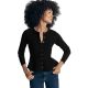 A woman wearing a black peplum cardigan, blue jeans, and gold necklaces