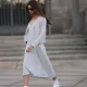 Jill Asemota seen wearing black vintage sunglasses, Dorothee Schumacher grey wool knit long dress, matching Dorothee Schumacher grey wool knit cardigan jacket, white cotton socks, Adidas white leather Samba sneakers, on November 04, 2023 in Berlin, Germany.