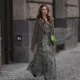 Anna Hiltrop seen wearing Boss green / beige / black print pattern pleated long dress, Boss brown suede leather jacket, Michael Kors green leather quilted crossbody bag and Gucci black leather laced boots, on February 16, 2024 in Berlin, Germany.